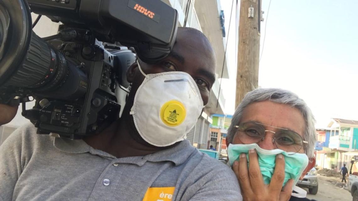 Tournage Caraïbes à la Dominique : Marco Calmot et Caroline Popovic portant des masques pour se protéger contre la poussière à Roseau