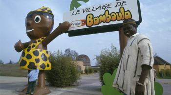 Un artisan ivoirien posant devant le village de Bamboula