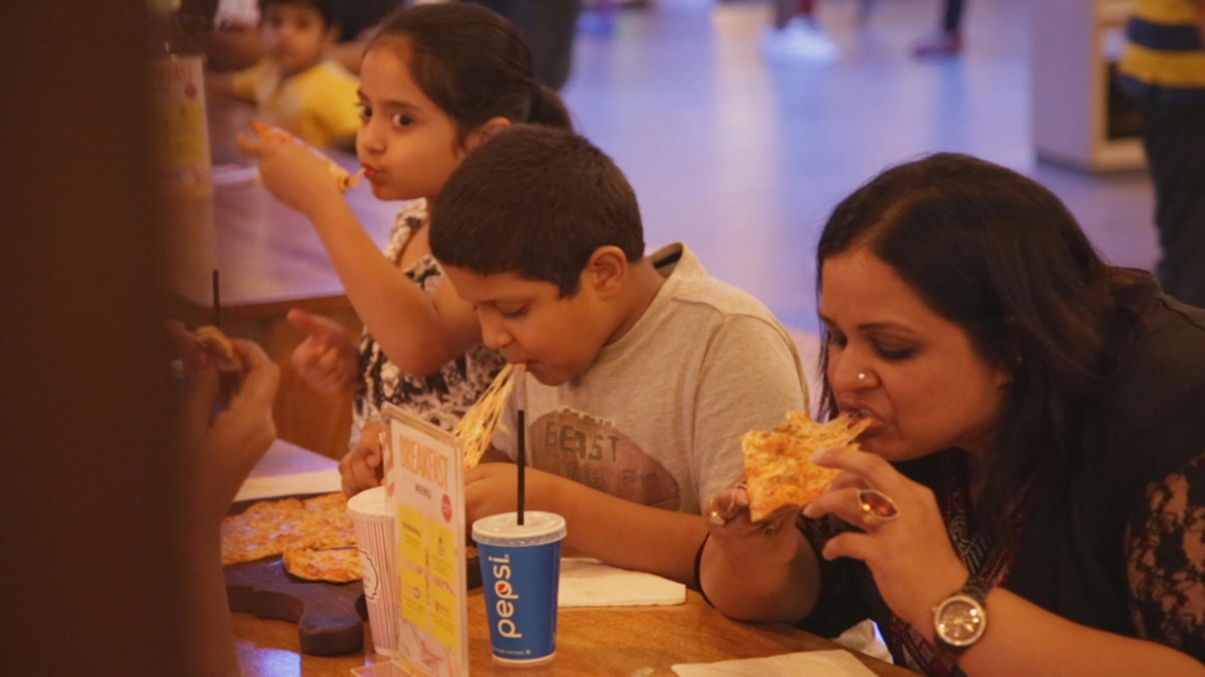 Des Indiens en train de manger des pizzas 