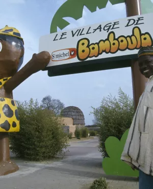 Le village de Bamboula Un artisan ivoirien posant devant le village de Bamboula