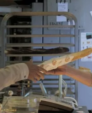 Client dans une boulangerie qui achète du pain