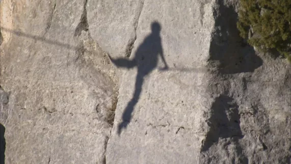 Ombre d'une silhouette assise sur un fil