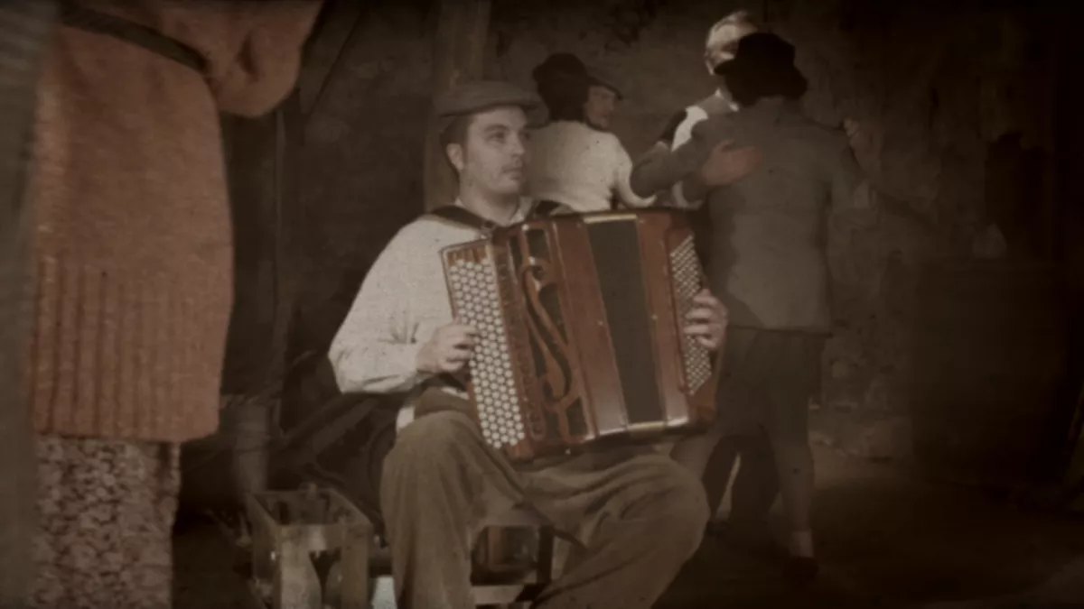 Le temps des bals clandestins Accordéoniste assis sur une chaise dans un bal