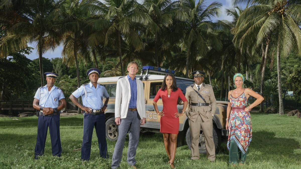 Danny JOHN-JULES (Dwayne Myers), Tobi BAKARE (JP Hooper), Kris MARSHALL (Humphrey Goodman), Joséphine JOBERT (Florence Cassell), Don WARRINGTON (Selwyn Patterson), Elizabeth BOURGINE (Catherine Bordey), photo générale pour la saison 6 de Meurtres au paradis