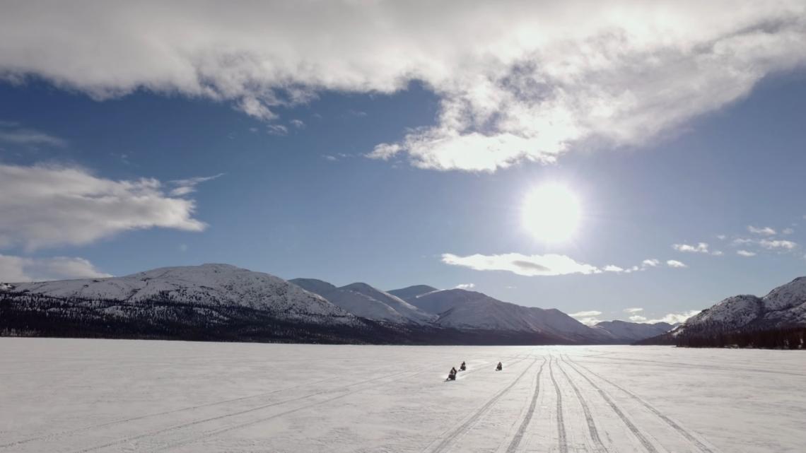 Des motos-neige sur un lac gelé dans le Yukon