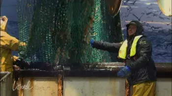 Pêcheur sur un chalutier à côté d'un filet