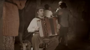 Accordéoniste assis sur une chaise dans un bal