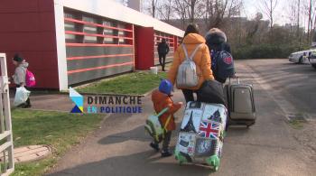 Réfugiés ukrainiens de dos avec leurs valises