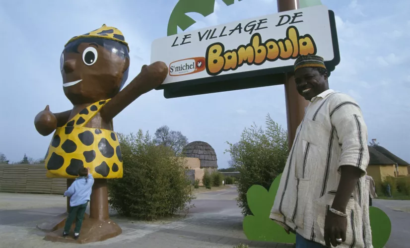 Un artisan ivoirien posant devant le village de Bamboula